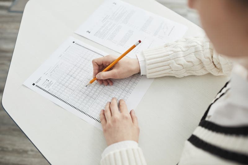 Student writing at a desk during study